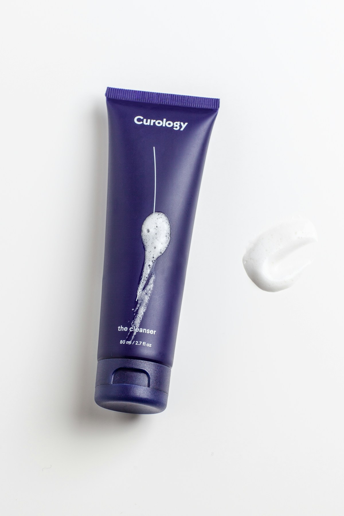 White-background skincare product photography on marble surface with soft directional lighting